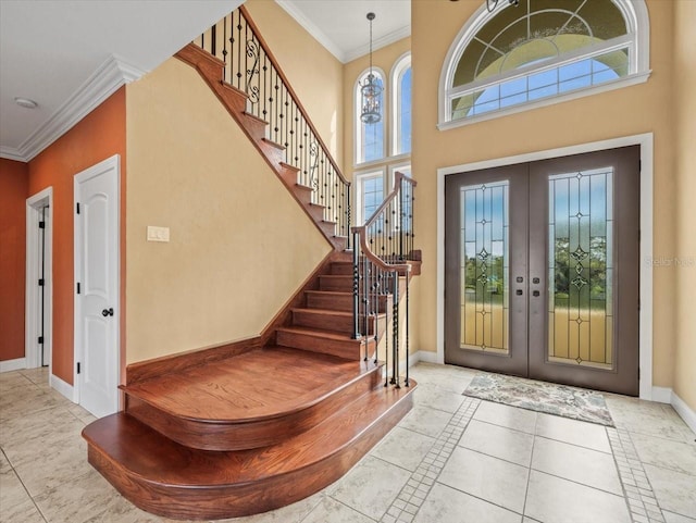 foyer entrance with a healthy amount of sunlight, baseboards, french doors, and ornamental molding