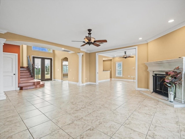 unfurnished living room with a glass covered fireplace, a healthy amount of sunlight, crown molding, and arched walkways