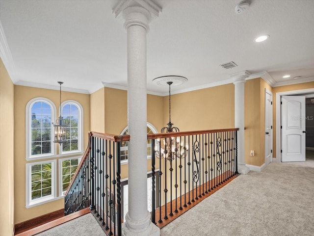 hallway featuring visible vents, baseboards, an upstairs landing, carpet floors, and a chandelier