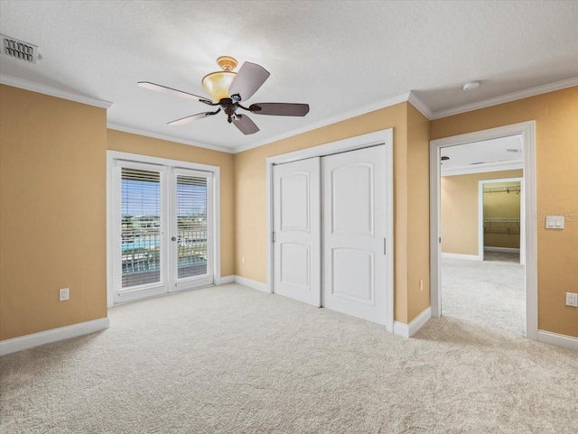 unfurnished bedroom featuring carpet floors, ornamental molding, visible vents, and access to exterior