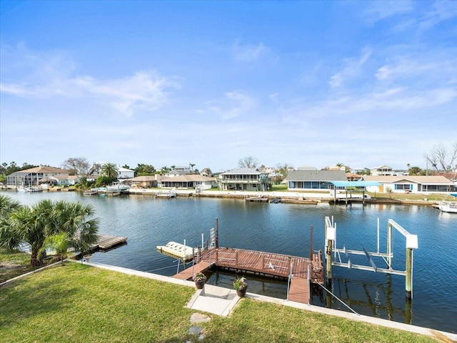 dock area featuring a water view, a lawn, and boat lift