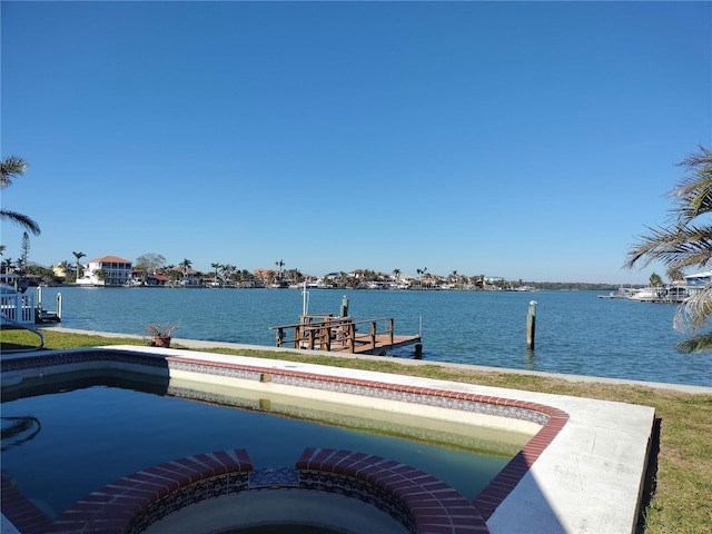 view of dock with a water view and a pool with connected hot tub