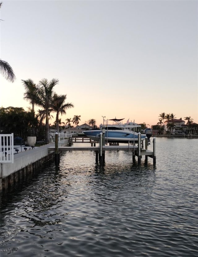 dock area with boat lift and a water view