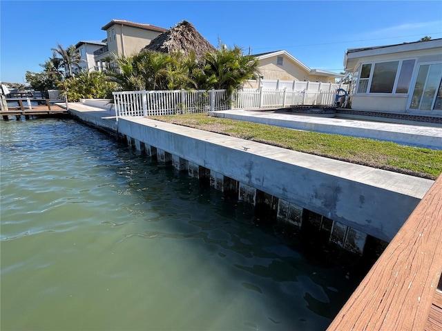 view of dock featuring a water view and fence