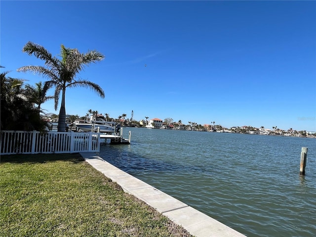 dock area featuring a yard, a water view, and fence