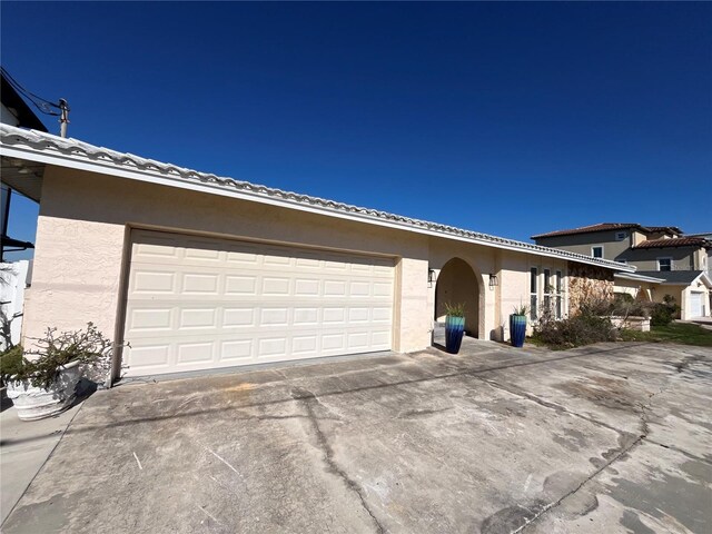 view of front of home featuring stucco siding, concrete driveway, an attached garage, and a tiled roof