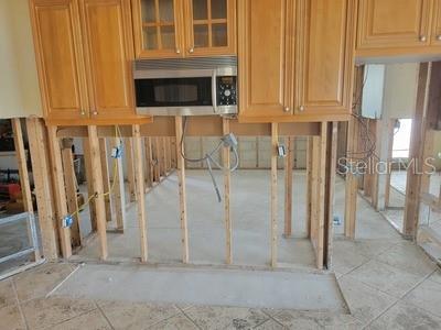 kitchen with stainless steel microwave and glass insert cabinets