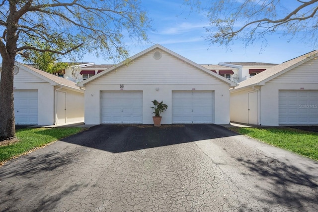 exterior space with a garage, stucco siding, and an outdoor structure