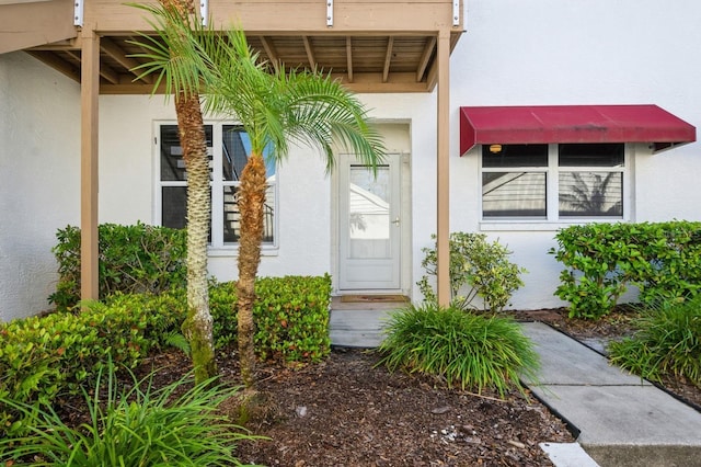 entrance to property featuring stucco siding