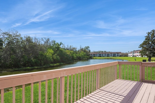 wooden terrace featuring a water view and a yard