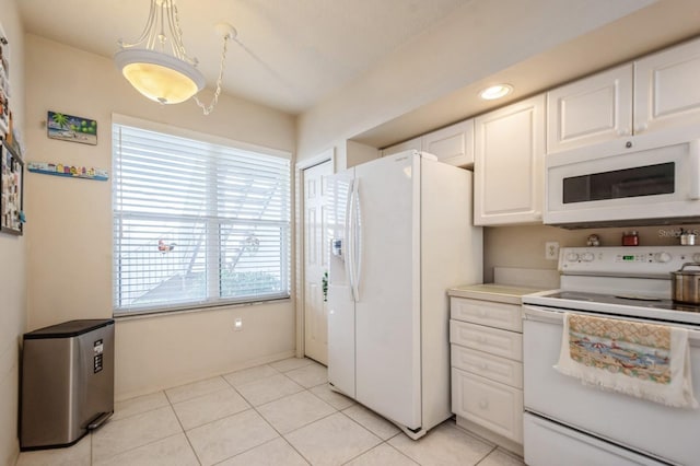 kitchen with white appliances, white cabinetry, light countertops, and light tile patterned flooring