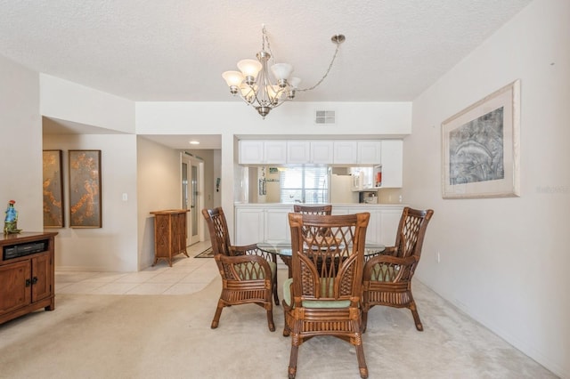 dining area featuring light tile patterned floors, a textured ceiling, light carpet, visible vents, and an inviting chandelier