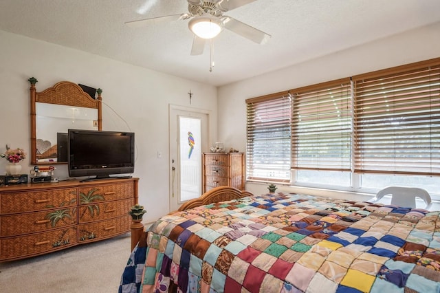 bedroom featuring ceiling fan, carpet floors, and a textured ceiling