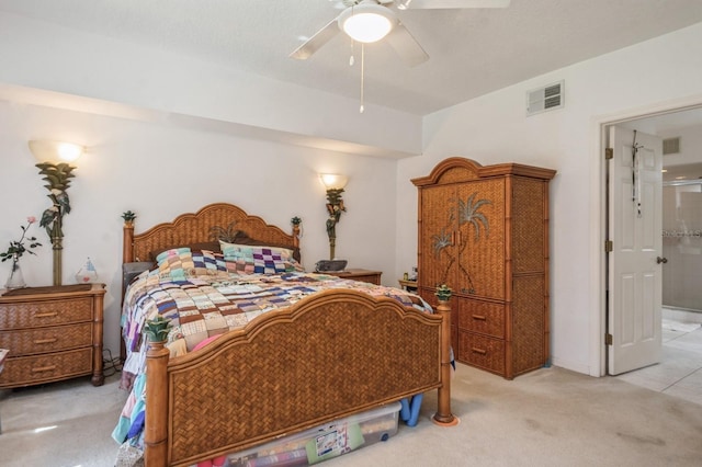 bedroom featuring light carpet, ceiling fan, ensuite bath, and visible vents