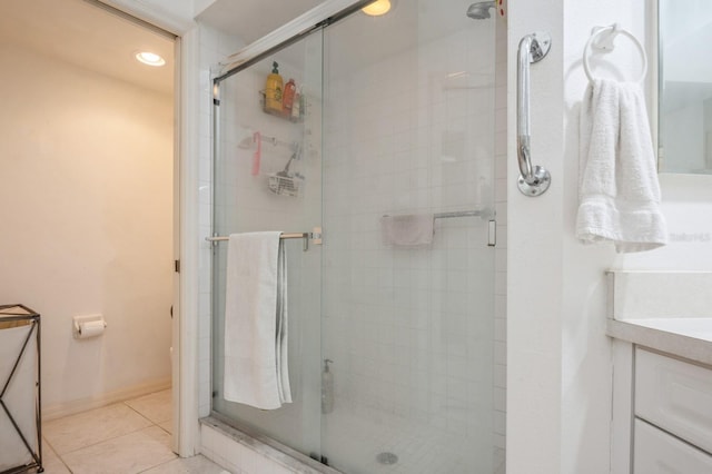 bathroom with a stall shower, tile patterned flooring, vanity, and baseboards