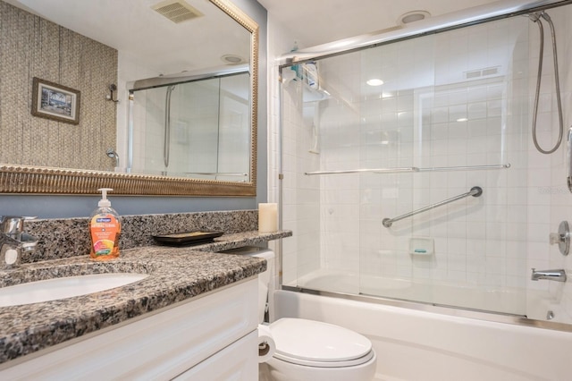 full bathroom featuring toilet, combined bath / shower with glass door, vanity, and visible vents