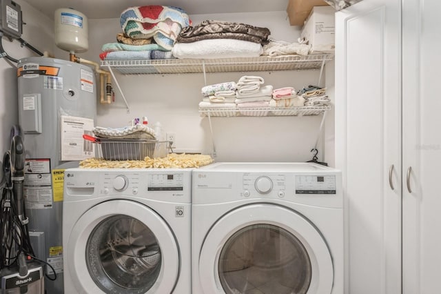 washroom featuring laundry area, electric water heater, and washer and dryer