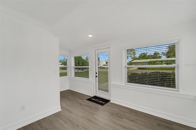 doorway to outside featuring crown molding, baseboards, and wood finished floors