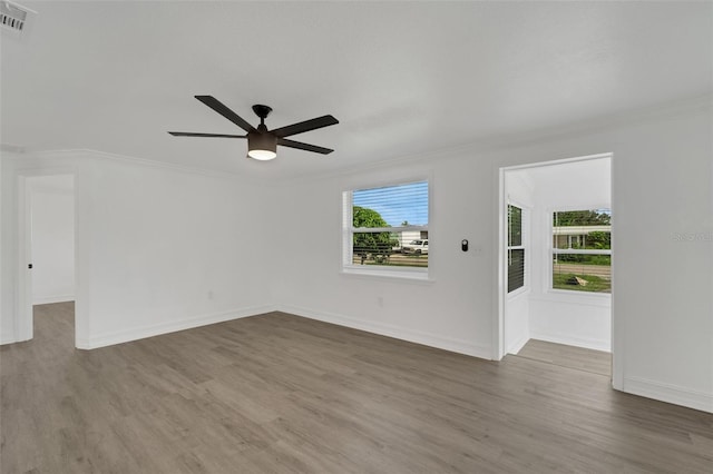 spare room featuring visible vents, ornamental molding, ceiling fan, and wood finished floors