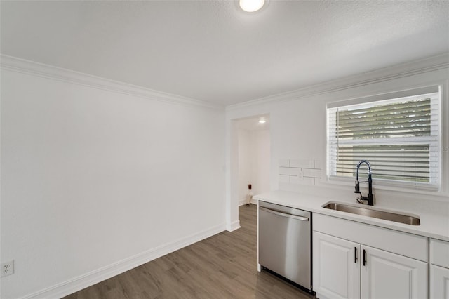 kitchen with white cabinets, dark wood finished floors, dishwasher, crown molding, and a sink