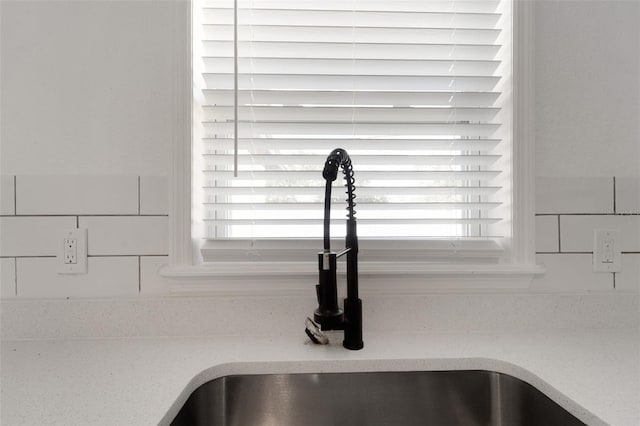 details featuring light stone counters and a sink