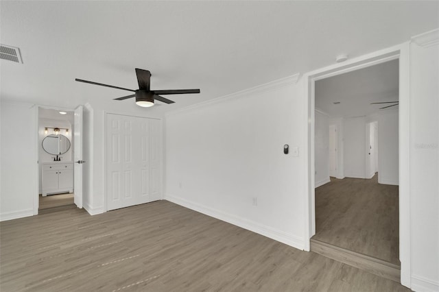 interior space featuring a ceiling fan, baseboards, visible vents, and wood finished floors