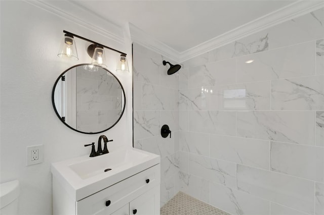 bathroom with toilet, a tile shower, vanity, and crown molding