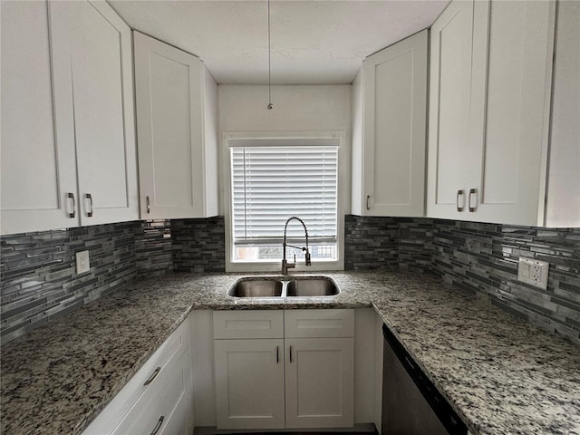 kitchen featuring white cabinets, a sink, backsplash, and stainless steel dishwasher