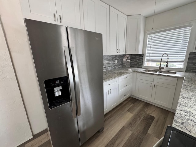 kitchen featuring a sink, white cabinets, stainless steel refrigerator with ice dispenser, backsplash, and dark wood-style floors