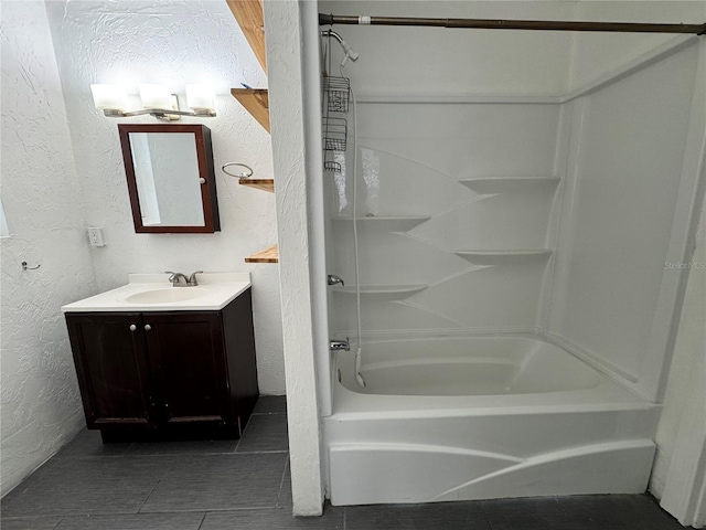 bathroom with bathing tub / shower combination, vanity, tile patterned flooring, and a textured wall