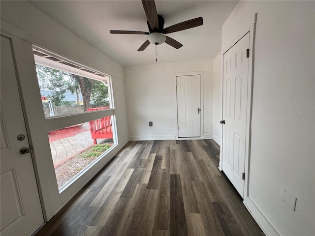 interior space featuring dark wood-style floors, ceiling fan, and baseboards