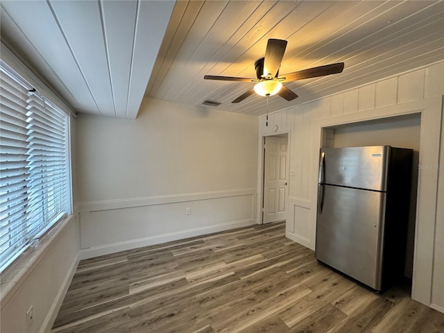 interior space featuring wooden ceiling, a ceiling fan, visible vents, and wood finished floors