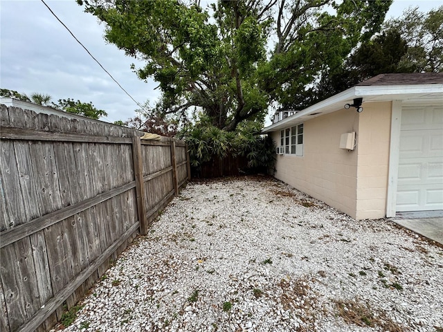 view of yard featuring a garage and fence