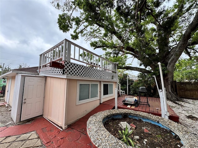 back of property with fence and a wooden deck