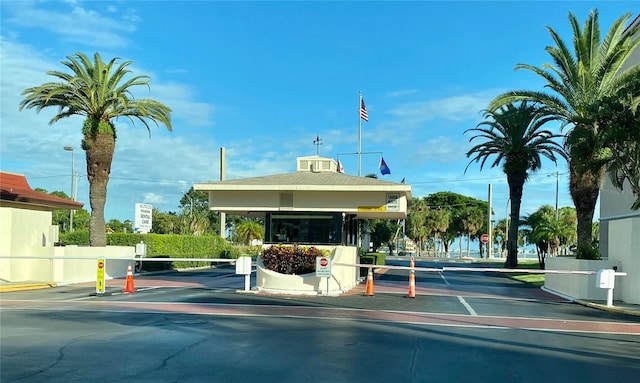 view of road with curbs, a gated entry, and traffic signs