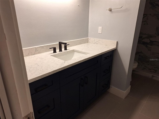 full bath with toilet, vanity, baseboards, a shower stall, and tile patterned floors