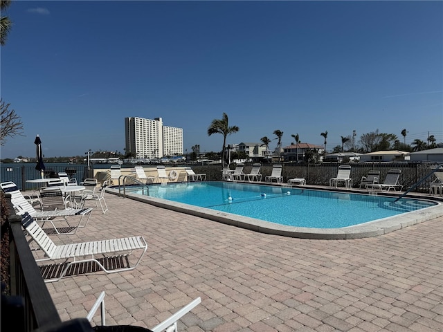 pool with a patio area and fence