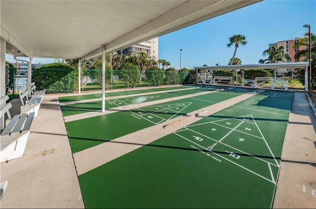 view of home's community with shuffleboard and fence