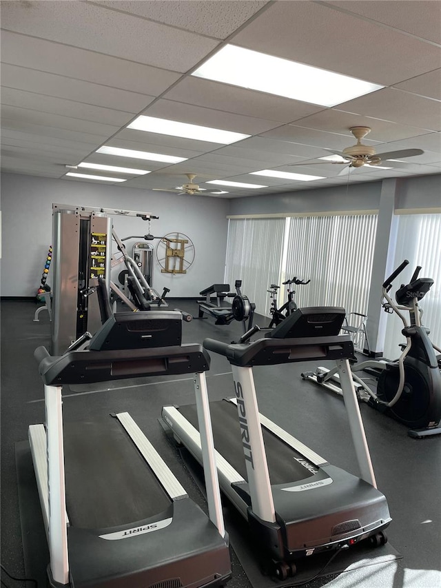 gym featuring ceiling fan and a drop ceiling