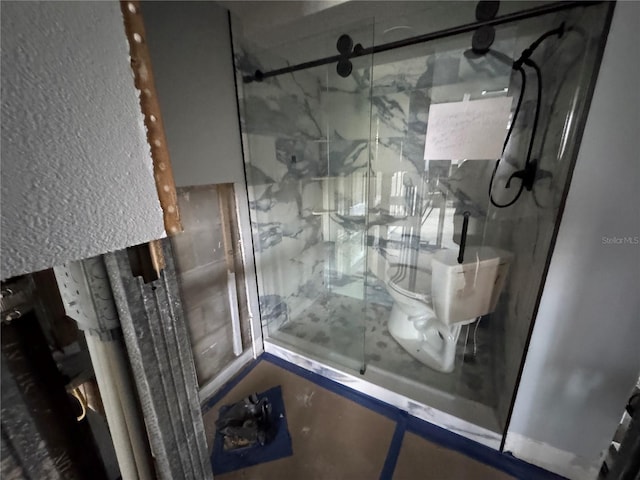 bathroom with a marble finish shower and toilet