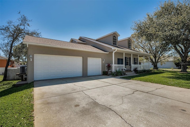 view of front facade featuring a front lawn, covered porch, stucco siding, driveway, and an attached garage