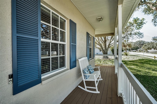 deck featuring a lawn and a porch