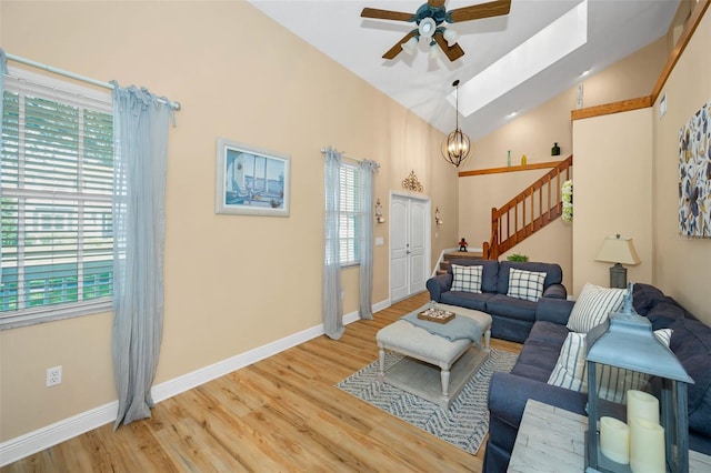 living room featuring stairway, light wood-style flooring, and a healthy amount of sunlight