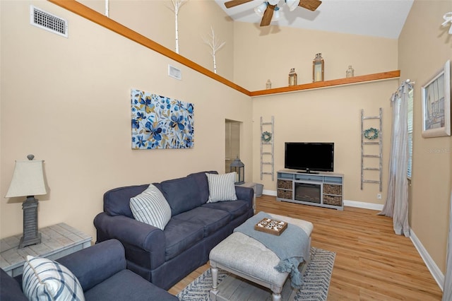 living room with visible vents, a ceiling fan, baseboards, and wood finished floors