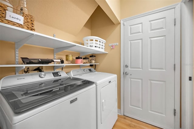 laundry room featuring light wood-type flooring, washing machine and dryer, and laundry area