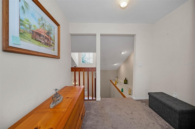 corridor featuring carpet and an upstairs landing