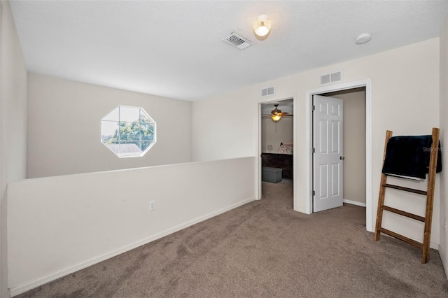 carpeted spare room with visible vents and baseboards