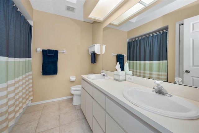 bathroom with a sink, visible vents, a skylight, and tile patterned floors