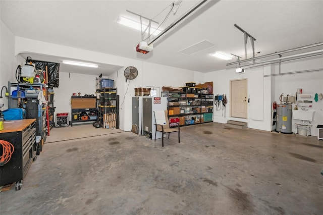 garage featuring a workshop area, electric water heater, a garage door opener, and a sink