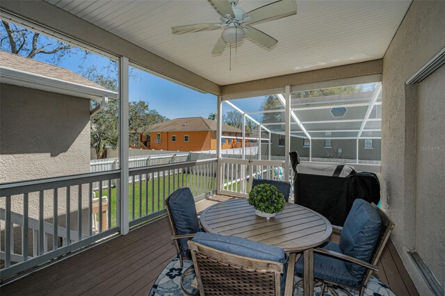 sunroom / solarium featuring a residential view and ceiling fan